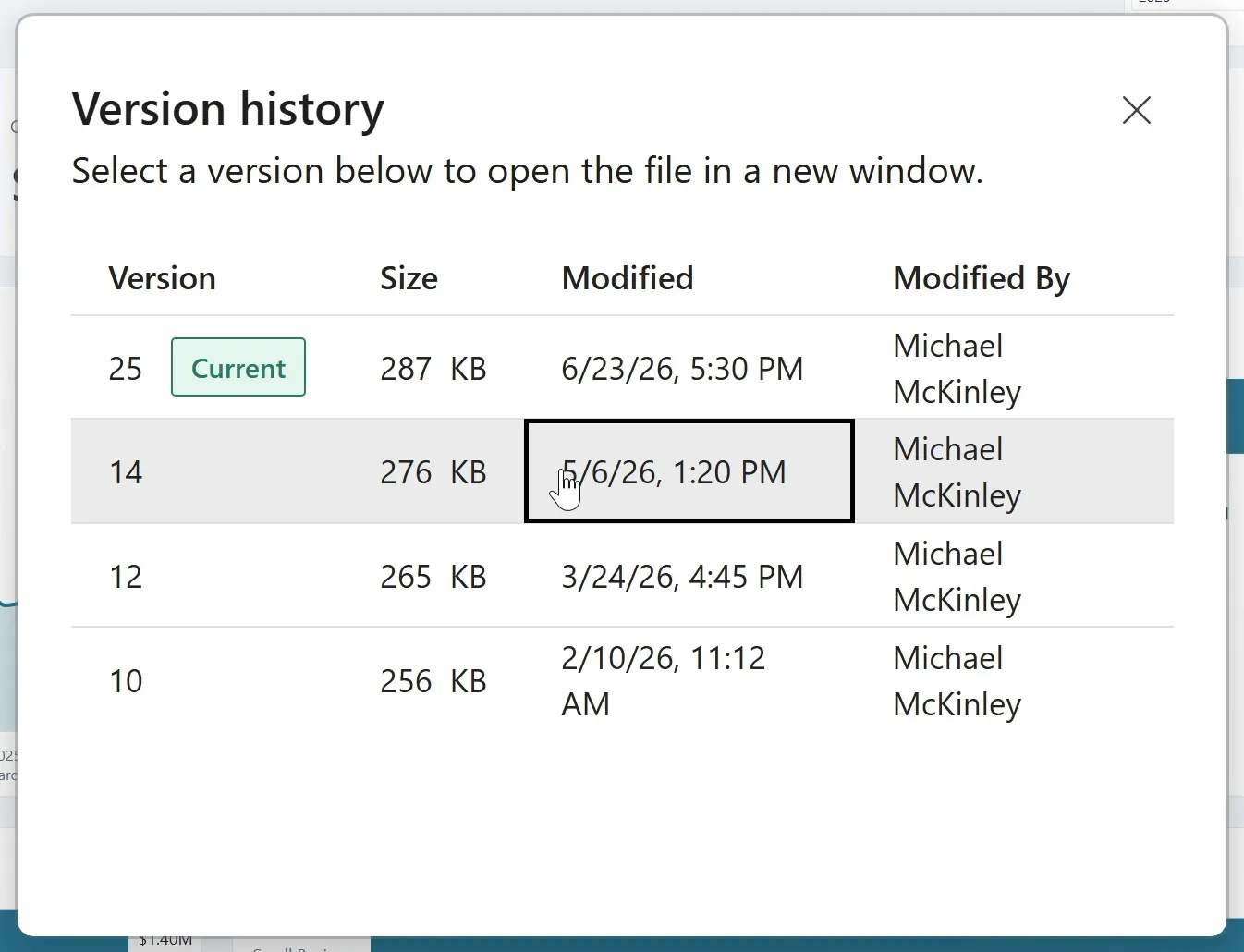 The Version history dialog in Power BI Desktop, over the report. It reads: Select a version below to open the file in a new window. Four columns: Version, Size, Modified and Modified By. Version 25, tagged Current, is 287 KB; version 14 is 276 KB; version 12 is 265 KB; version 10 is 256 KB. Michael McKinley modified every version. The pointer is on version 14's row.